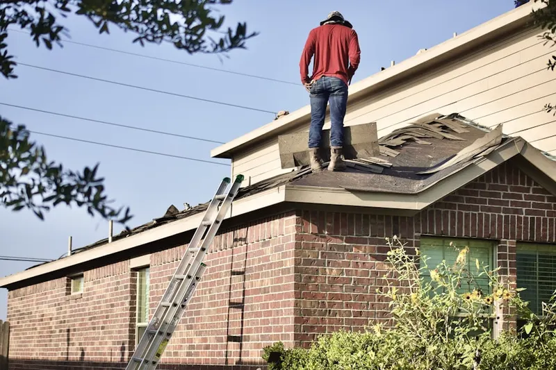 Professional roofer working on a residential roof in Cataumet